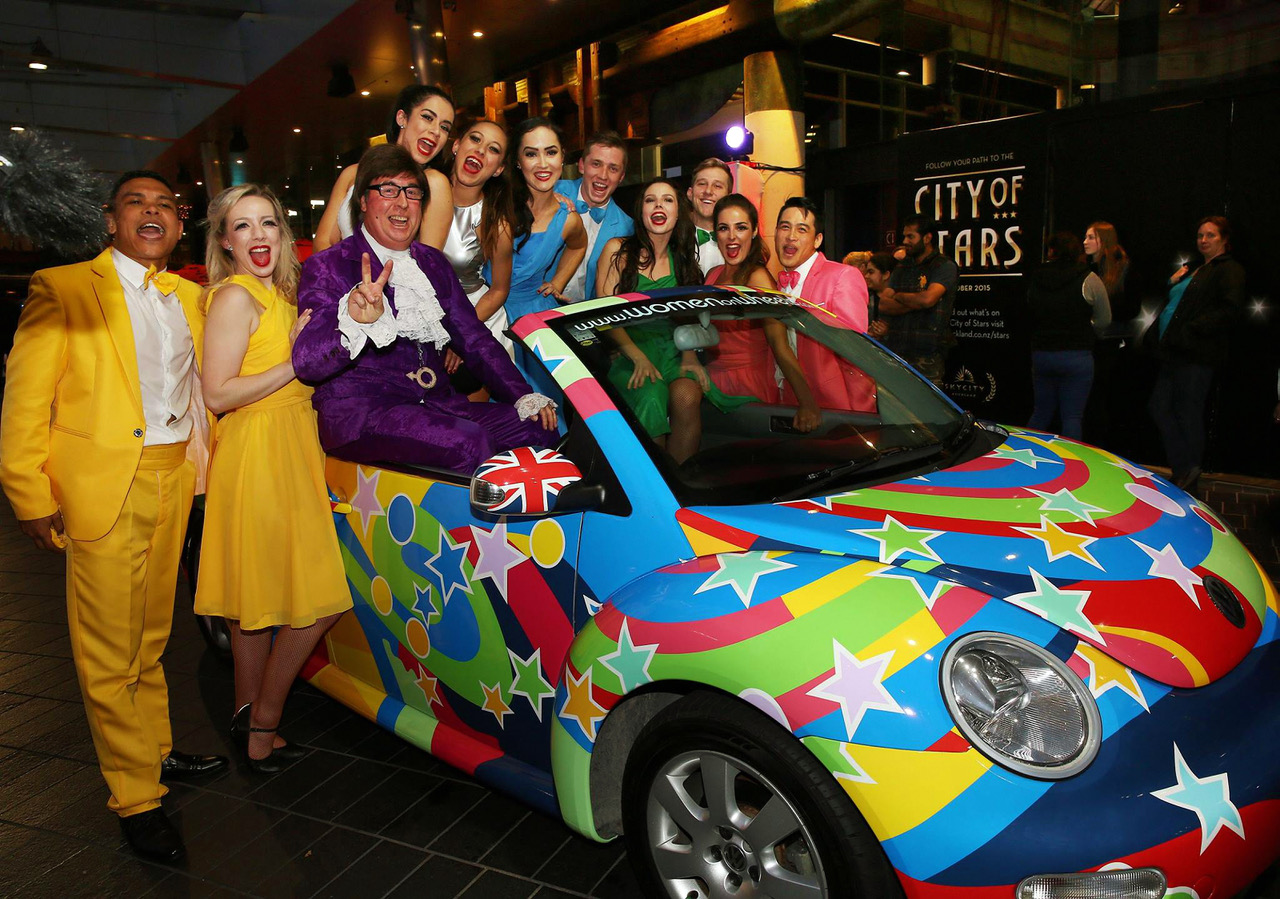 Austin Powers on the psychedelic car with cheering guests at a Sky City casino night