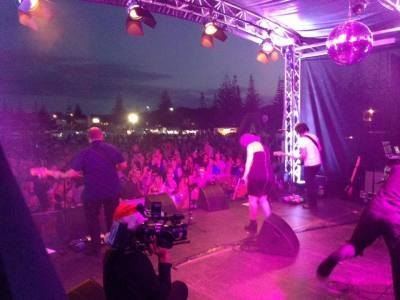 Crowd bathed in pink and purple stage lighting at night