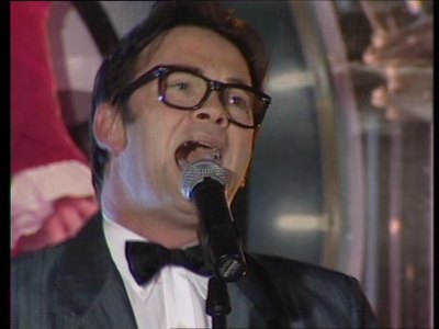 Buddy Holly tribute artist in glasses and bow tie
