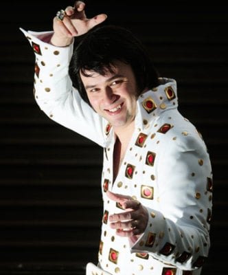 Elvis tribute artist in a white jumpsuit