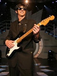 Tribute guitarist in a suit playing an electric guitar